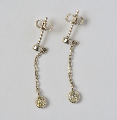 null Pair of 14K (585/oo) white gold earrings, each consisting of a stud set with...