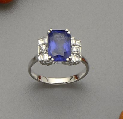 null 18K (750/oo) white gold ring centered on a rectangular cut Ceylon sapphire weighing...