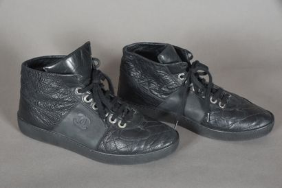 null CHANEL. Pair of black quilted leather high-top sneakers, laces on eyelets signed....