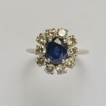 null *18K (750/oo) white gold and platinum (850/oo) ring centered on an oval sapphire...