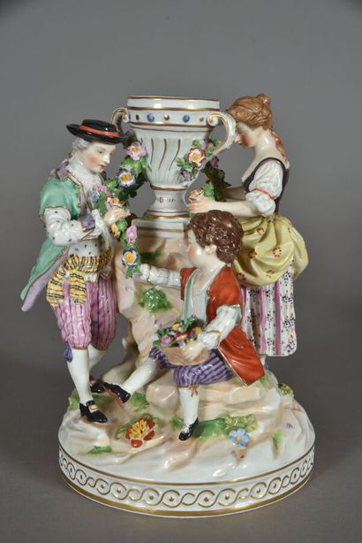 null Sujet en porcelaine à décor polychrome animé de trois personnages. Marqué au...