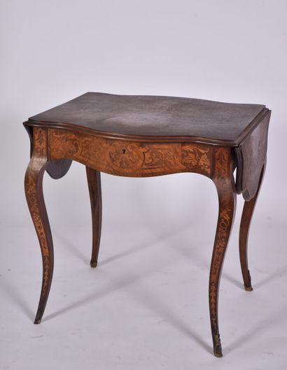 null * Table in rosewood and rosewood veneer drawing foliage scrolls in reserves,...
