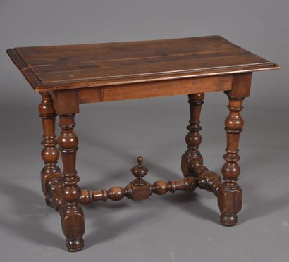 Walnut table, resting on four turned baluster...