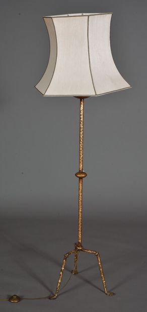 Forged tube floor lamp, gilded, resting on...
