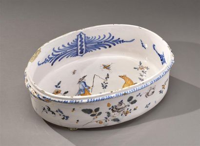 null ROANNE. 
Rare oval jardinière with polychrome and blue decoration, in the center...