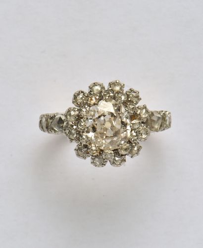 null 18K (750/oo) 2-tone gold ring centered with an oval old-cut diamond calibrating...