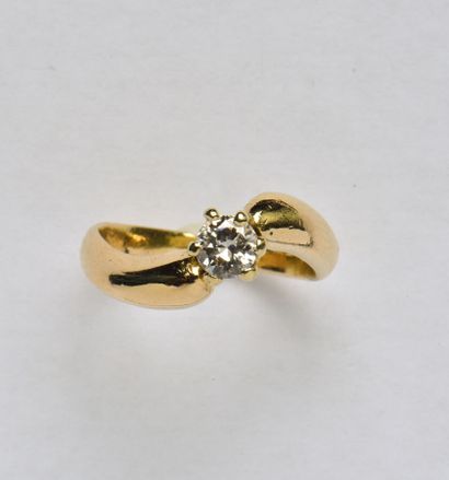 null Bague solitaire en or jaune 18K (750/oo), l'anneau sinueux centré d'un diamant...