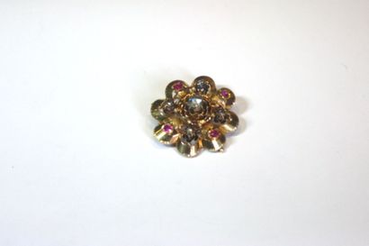 null Broche fleur en or jaune ajouré et ciselé, ornée de rubis et de diamants taillés...