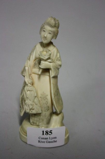 null Statuette en ivoire sculptée, jeune femme debout tenant un éventail et une fleur.

Chine...