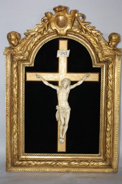null Christ en ivoire sculpté sur croix, cadre en bois sculpté doré de feuillages,...