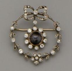 null Broche en argent (800/oo) et or 18K (750/oo) a décor de guirlande de fleurs...