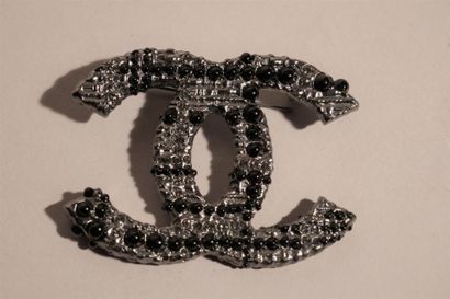 null CHANEL, Paris. Broche en métal argenté, strass et demi-perles noires. 7X7 cm....