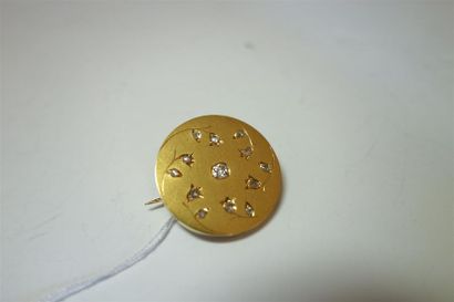 null Broche ronde en or jaune 18K (750/oo) à décor floral sertie d'un diamant taille...