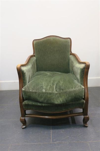 Un fauteuil garniture de velours vert.