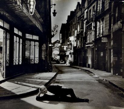 ALEXANDRE TRAUNER (1906-1993) Trauner allongé dans un décor de rue de Paris pour...