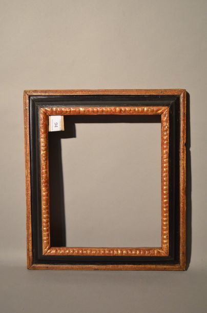 null RVERSE PROFILE FRAME in black and gold carved wood with gadroons decoration...