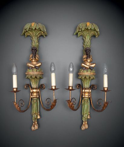 null A pair of amusing two-light sconces in carved, gilded and rechambered wood and...