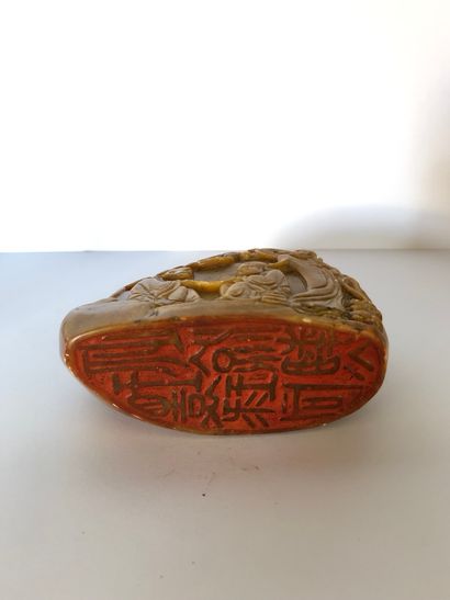 CHINE - Vers 1900 Beige and red steatite rock-shaped cachet carved with three Luohan...