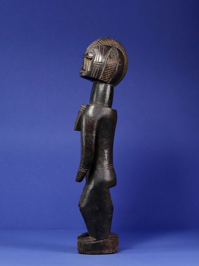  Statue représentant un personnage féminin debout, les épaules et la poitrine projetés...