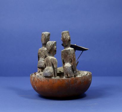  Demi calebasse votive comprenant trois statuettes en bois, un crâne de chien et...