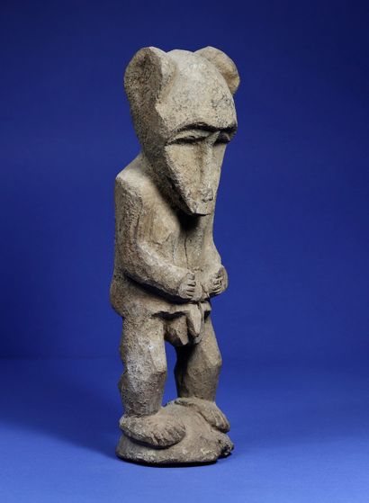  Rare anthropo-zoomorphic male statue in a standing position, arms along the body,...