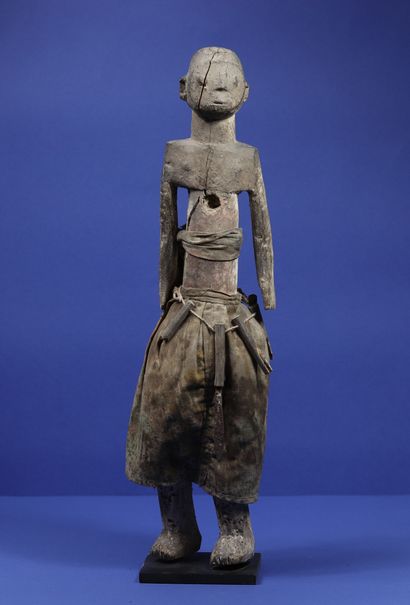 null 
Wooden statue representing a standing figure dressed in a cloth skirt and a...