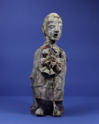 null 
Wooden votive statue representing a female figure covered with pieces of fabric...