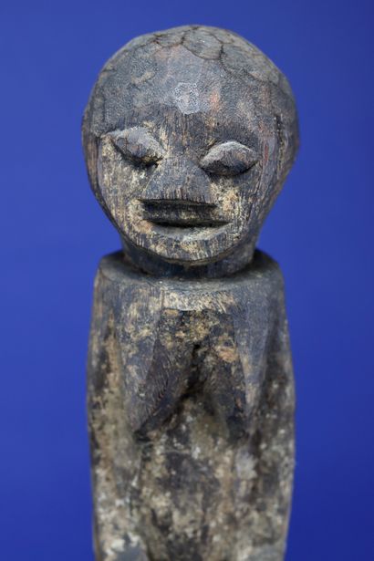 null 
Wooden botchio post representing a female figure standing on a truncated cone...