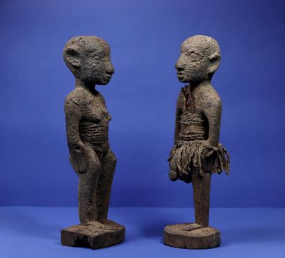 null 
Couple of wooden votive statues covered with a thick crusty material, the trunks...