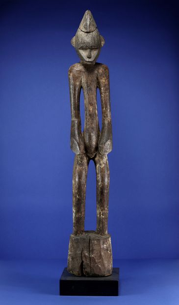 null 
Imposing statue of a male figure standing with his arms at his sides, the ends...