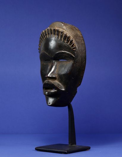 null 
Mask decorated with a row of small horns carved on the forehead, half-closed...