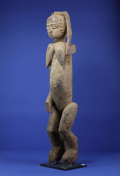  Importante statue féminine représentée debout, le bras gauche levé, la main posée...