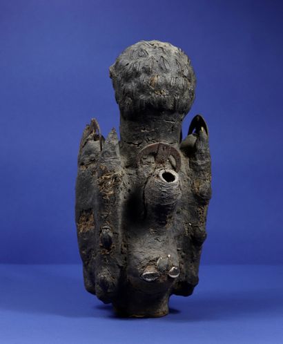 null 
Statue of a fetishist representing a wooden figure wearing a crown of cowries,...