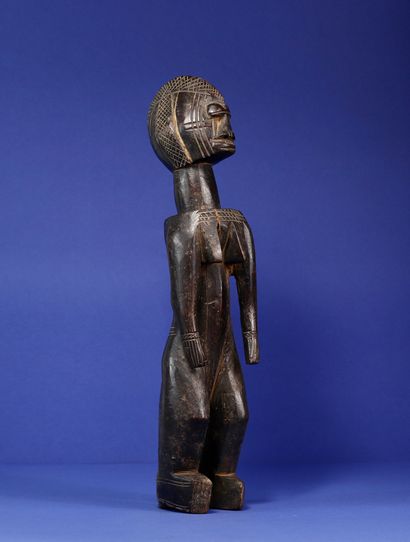  Statue représentant un personnage féminin debout, les épaules et la poitrine projetés...