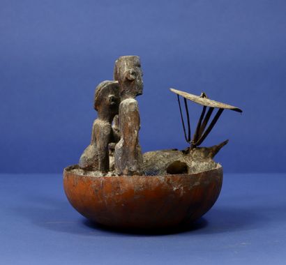 null 
Votive half calabash with three wooden statuettes, a dog skull and an iron...