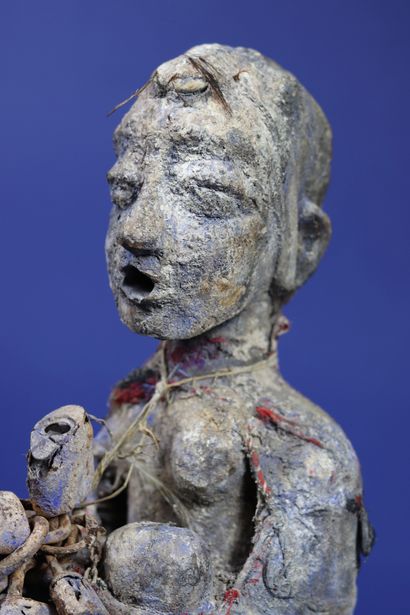 null 
Wooden votive statue representing a female figure covered with pieces of fabric...