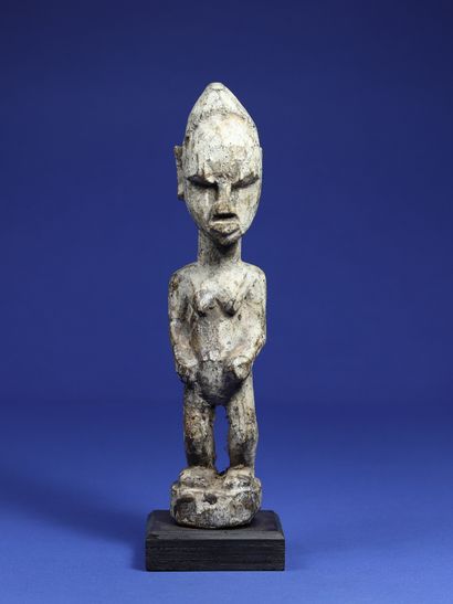  Female statuette with schematic features, wood with a sacrificial crusty patina...