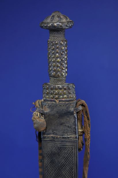  Saber in its leather scabbard decorated with embossed geometric patterns. Baule,...