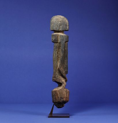 null 
Statue representing a standing figure with stylized features, arms along the...