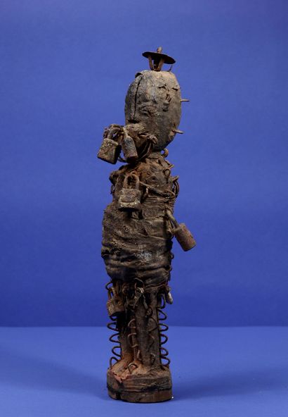  Statue votive en bois représentant un personnage debout, le corps couvert de nombreux...