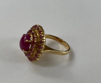  Ring in gold 750/°°°° Centered on a cabochon of rubies in a double circle of rubies...