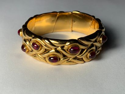 null 
Gold cuff bracelet with braided ribbons punctuated with red stone cabochons,...