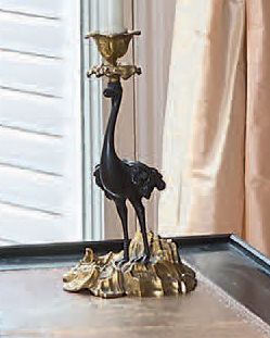 null A pair of chased, gilded or patinated bronze candlesticks in the form of standing...