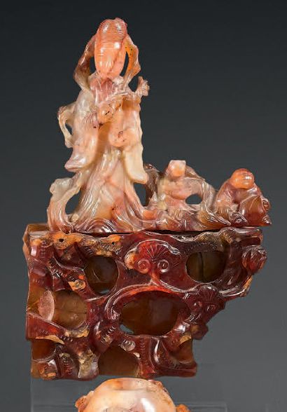 CHINE - XXe siècle Carved carnelian group of Guanyin and his two acolytes standing...