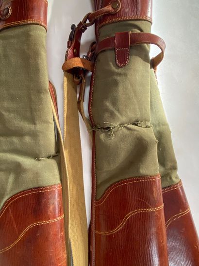 null Three green and brown canvas and leather rifle cases. Wear, tears.