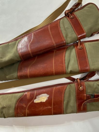 null Three green and brown canvas and leather rifle cases. Wear, tears.