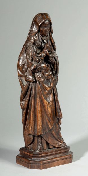 null Sainte Anne Trinitaire en noyer sculpté. La sainte porte Marie assise sur son...
