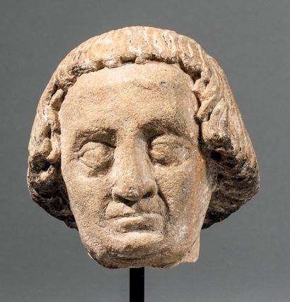 null Limestone head of a man sculpted in the round with traces of polychromy. Face...