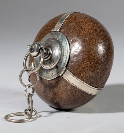 null Flattened sphere-shaped bezoar with silver mounting. It is encircled by three...