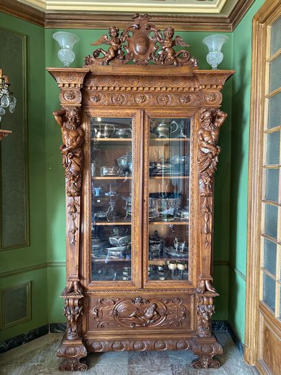 null Importante armoire vitrine en noyer richement sculpté ouvrant en façade par...